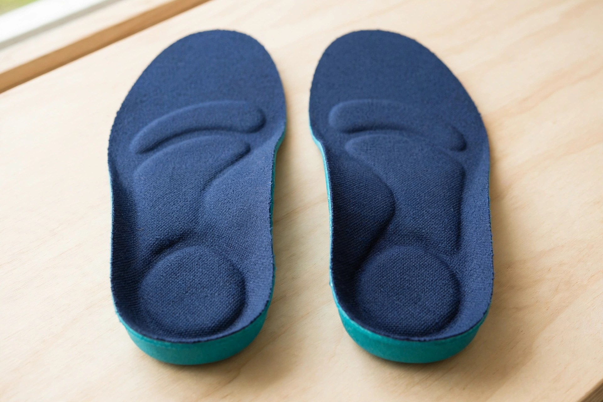 Pair of firm orthotic insoles with arch support